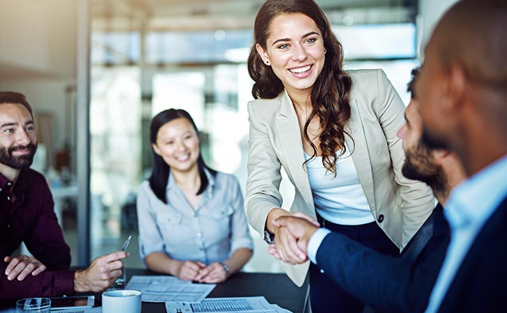 Smiling woman with team talking about corporate governance